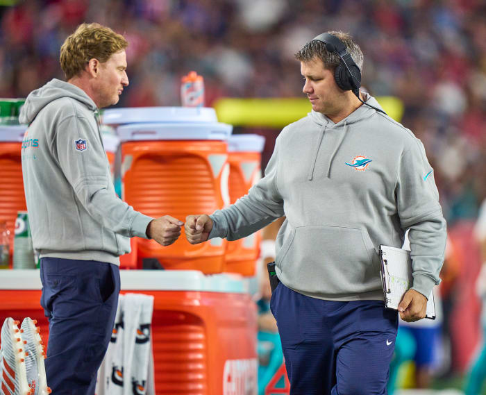 Dolphins video director Mike Nobler (left) gives a fist bump on the sideline during a game.